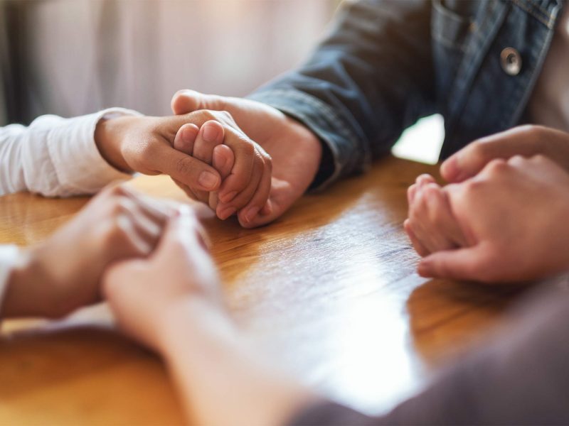 group-of-people-sitting-in-a-circle-holding-hands-2023-11-27-05-33-31-XCL6X4S.jpg